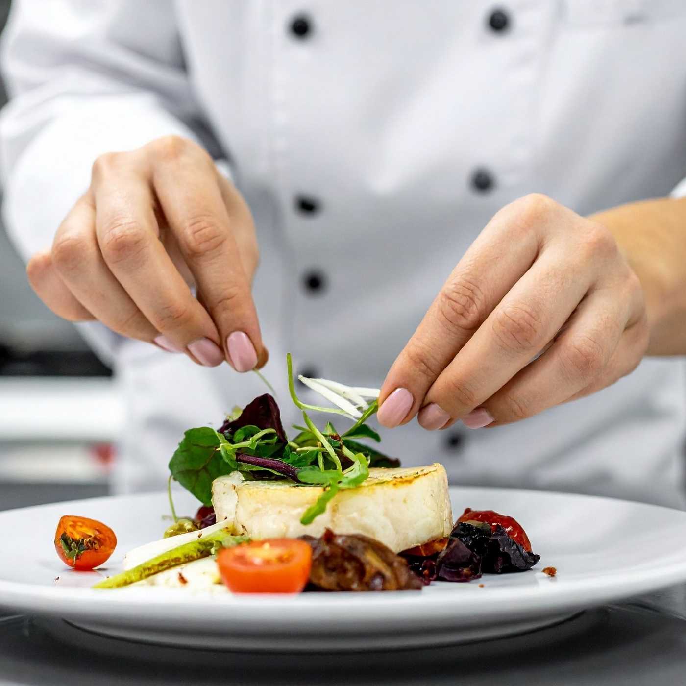 Former Chef Gabby Scott garnishing herbs on dinner plate for high end guests on charter yachts