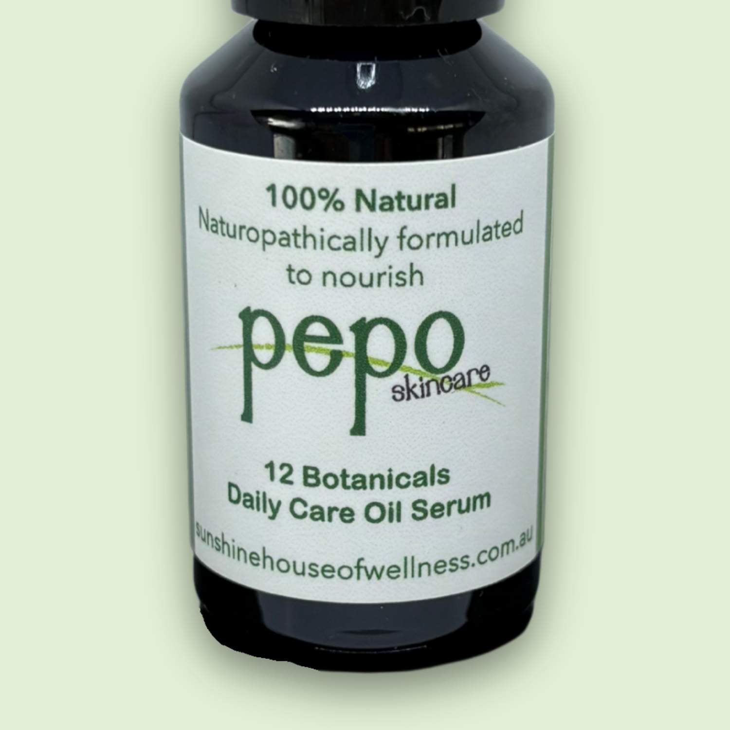 Bottle of pepo skincare 12 botanicals serum, 100% natural ingredients with a white label on a light green background
