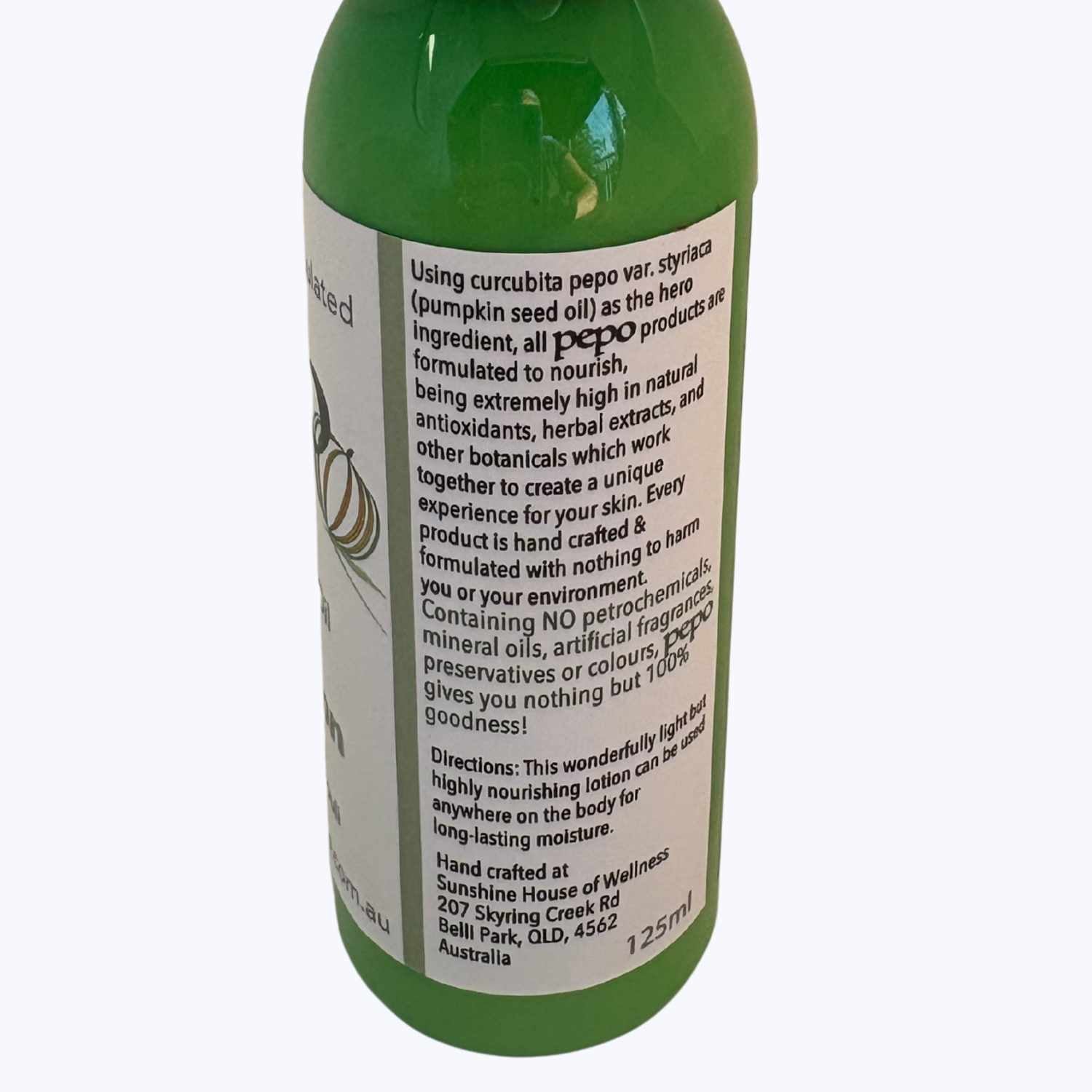 Green bottle of Pepo natural Australian Pumpkin Seed Oil Body Lotion, with directions for use, on a white background