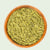 Wooden bowl filled with green Australian pumpkin seed meal on a light gray background