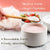 Neutral taste collagen peptides being scooped with a wooden spoon into a bowl of pink yoghurt, with strawberries in the background.