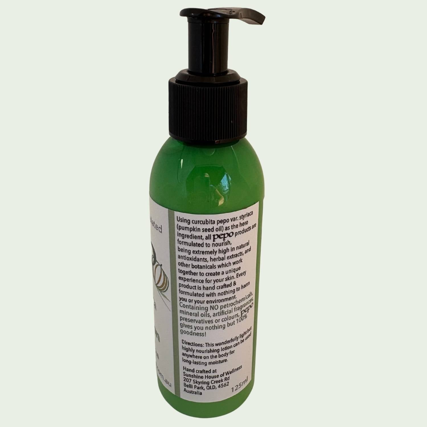 Green bottle of Pepo natural Australian Pumpkin Seed Oil Body Lotion, with directions for use, on a white background